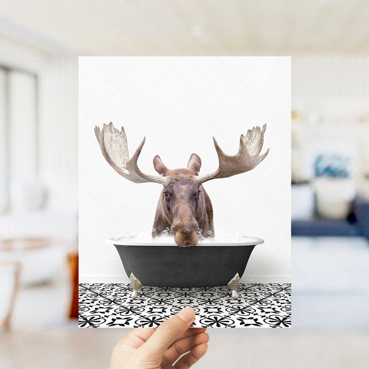 A moose with large antlers is sitting in a bathtub filled with water, creating a whimsical and humorous scene.