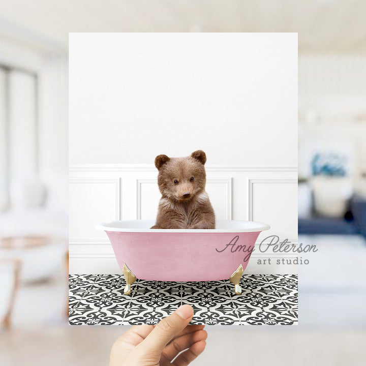 a person holding up a picture of a teddy bear in a bathtub