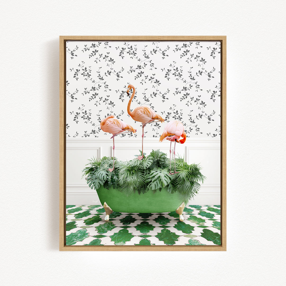 A framed image depicting three pink flamingos standing in a green planter filled with lush green plants, set against a patterned wall.