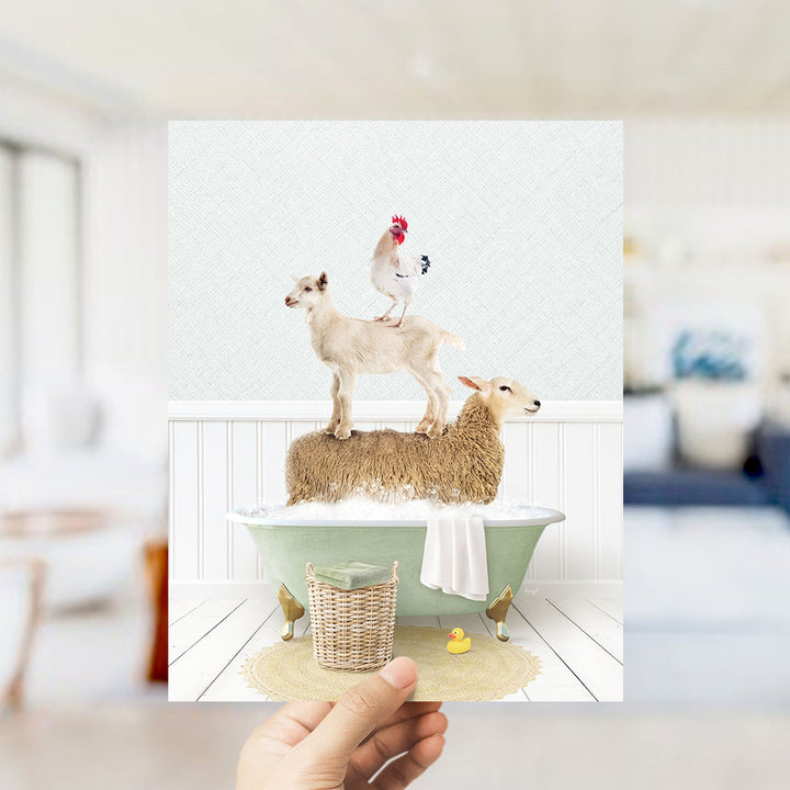 A hand holds up a framed image depicting a goat standing on a sheep's back in a bathtub, with a chicken perched on top.