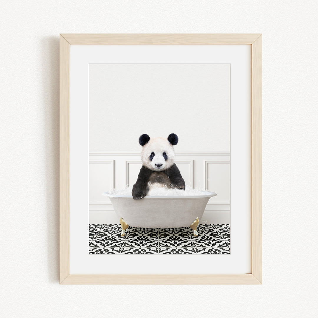 A panda bear sitting in a white bathtub filled with bubbles, surrounded by a black and white patterned rug.
