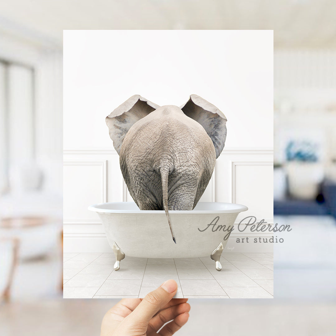 a person holding up a picture of an elephant in a bathtub