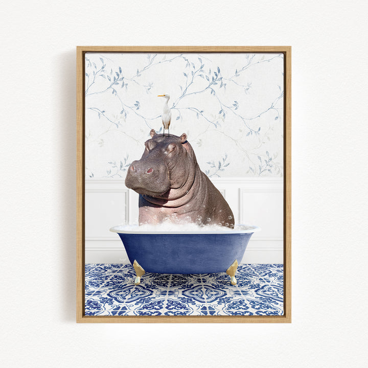 A framed image depicting a hippopotamus sitting in a bathtub, with a bird perched on its head.
