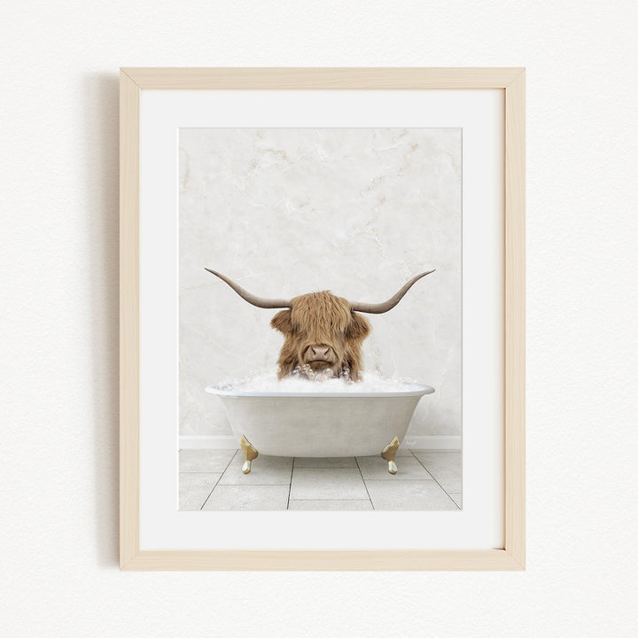A brown cow with long horns is sitting in a white bathtub filled with water, creating a whimsical and humorous scene.