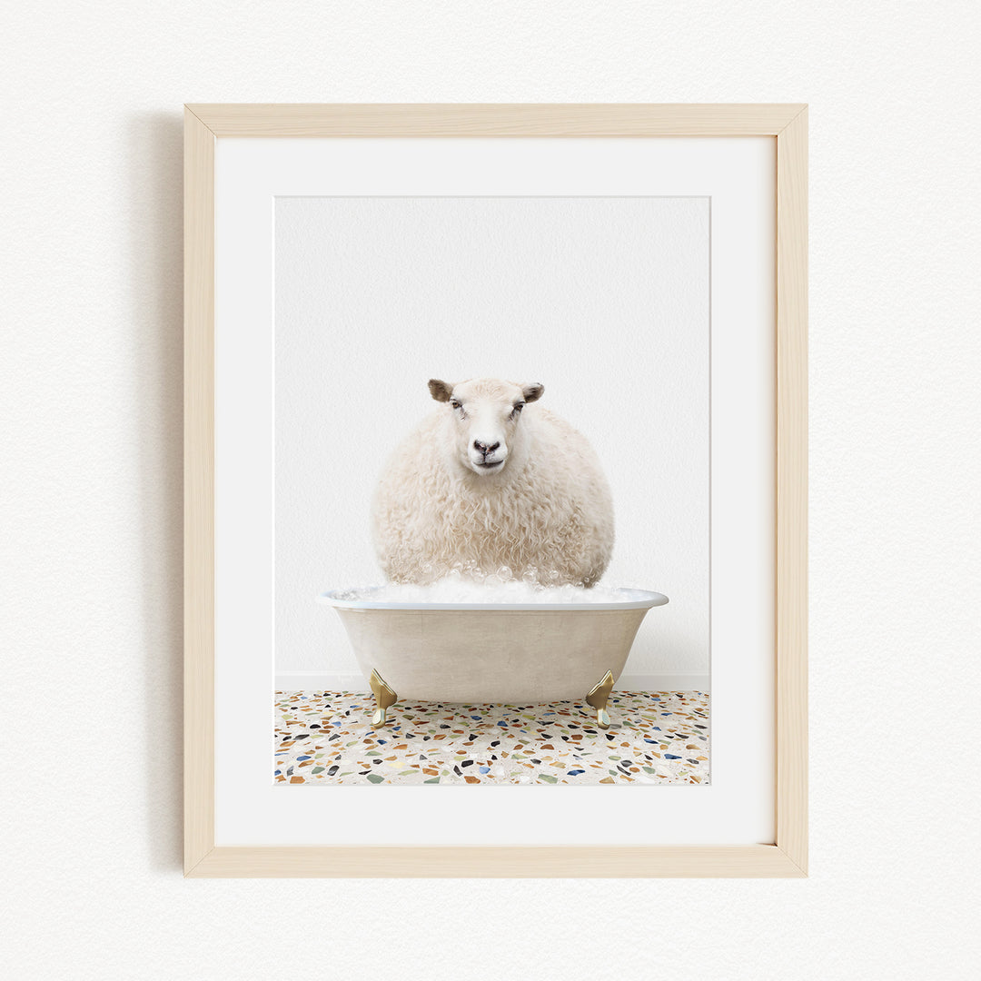 A fluffy white sheep sits in a white bathtub filled with bubbles, creating a whimsical and playful scene.