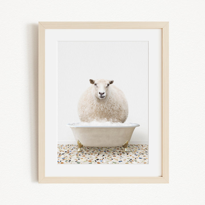A fluffy white sheep sits in a white bathtub filled with bubbles, creating a whimsical and playful scene.