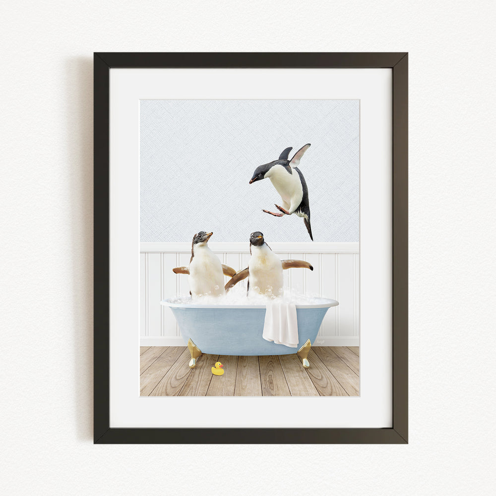 A framed image depicting two penguins sitting in a bathtub, with one penguin flying towards the other.
