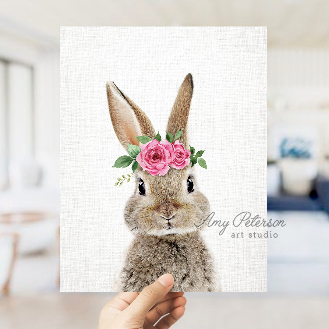 a person holding up a card with a picture of a rabbit wearing a flower crown