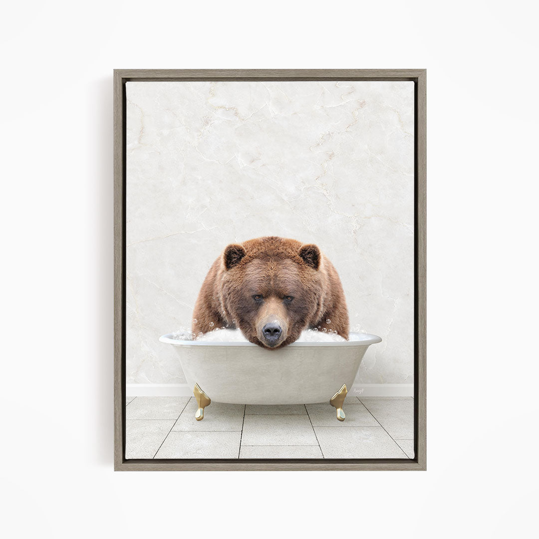 A brown bear is sitting in a white bathtub, appearing relaxed and enjoying the bath.