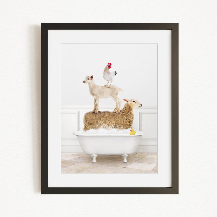 A framed image depicting a goat standing on a sheep's back while a rooster stands on top of a sheep in a bathtub.