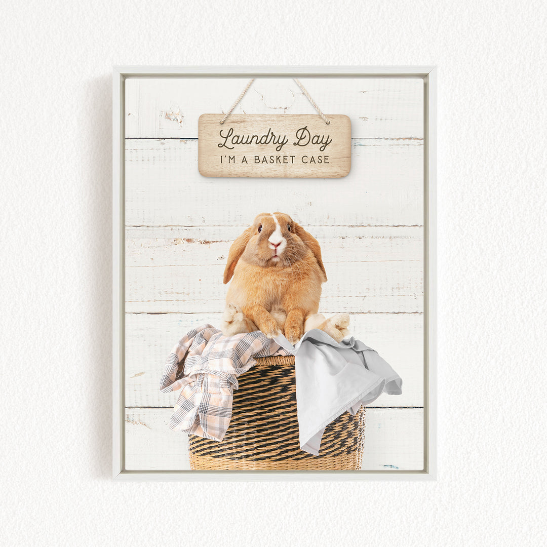 A wooden sign with the text "Laundry Day I'm a basket case" hangs above a woven basket containing clothes.