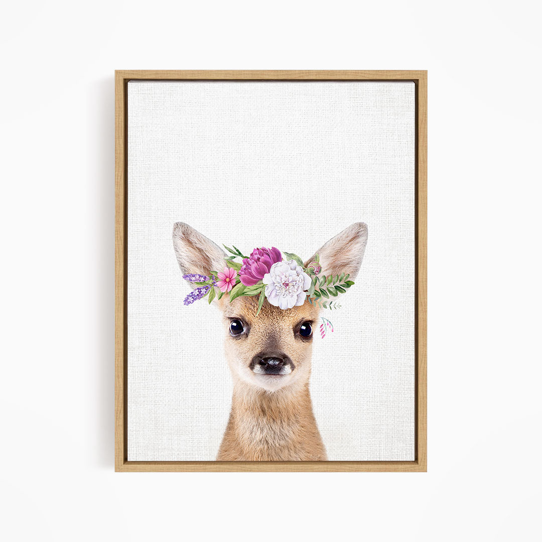A deer wearing a floral crown on its head, with a neutral background.