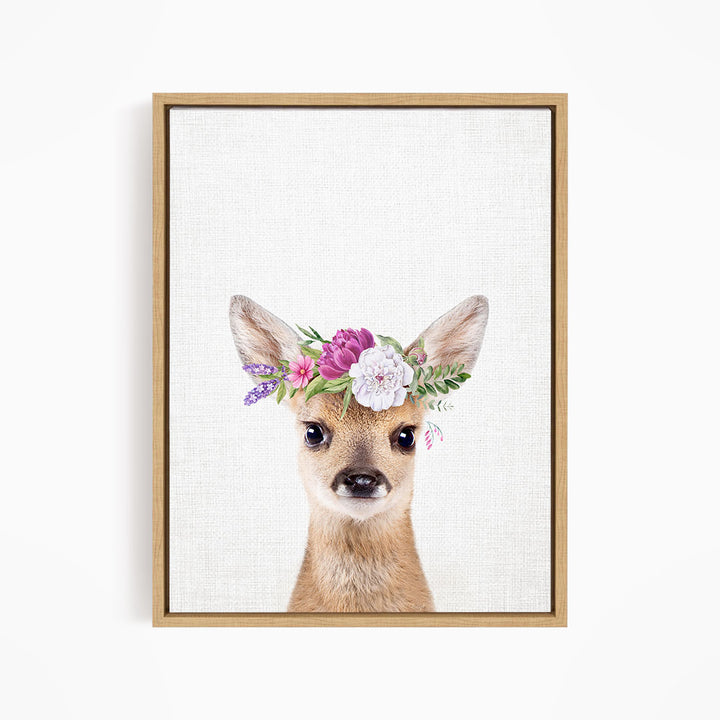 A deer wearing a floral crown on its head, with a neutral background.