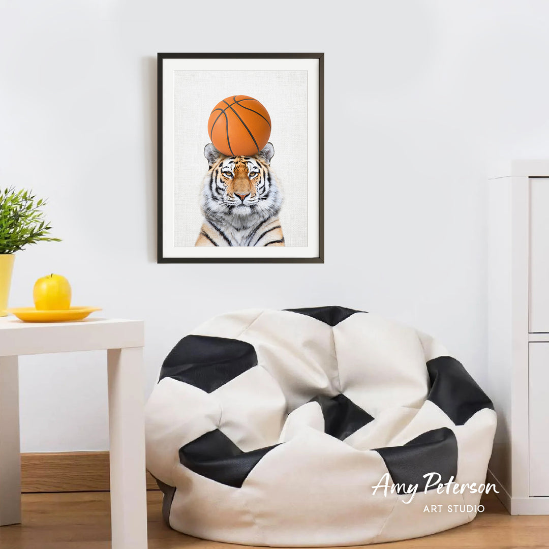a tiger wearing a basketball, with a framed print of the tiger on the wall above a white bean bag chair.