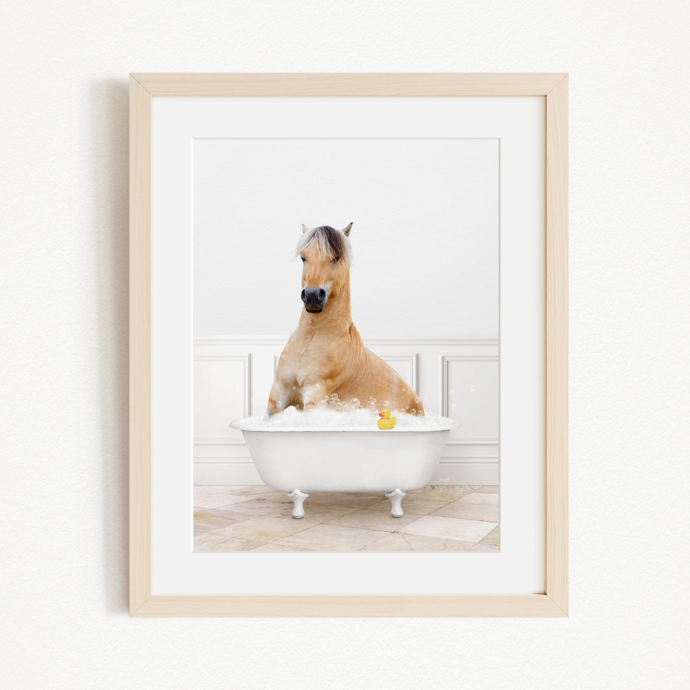 A brown horse sitting in a white bathtub filled with water, with a yellow rubber duck floating in the water.
