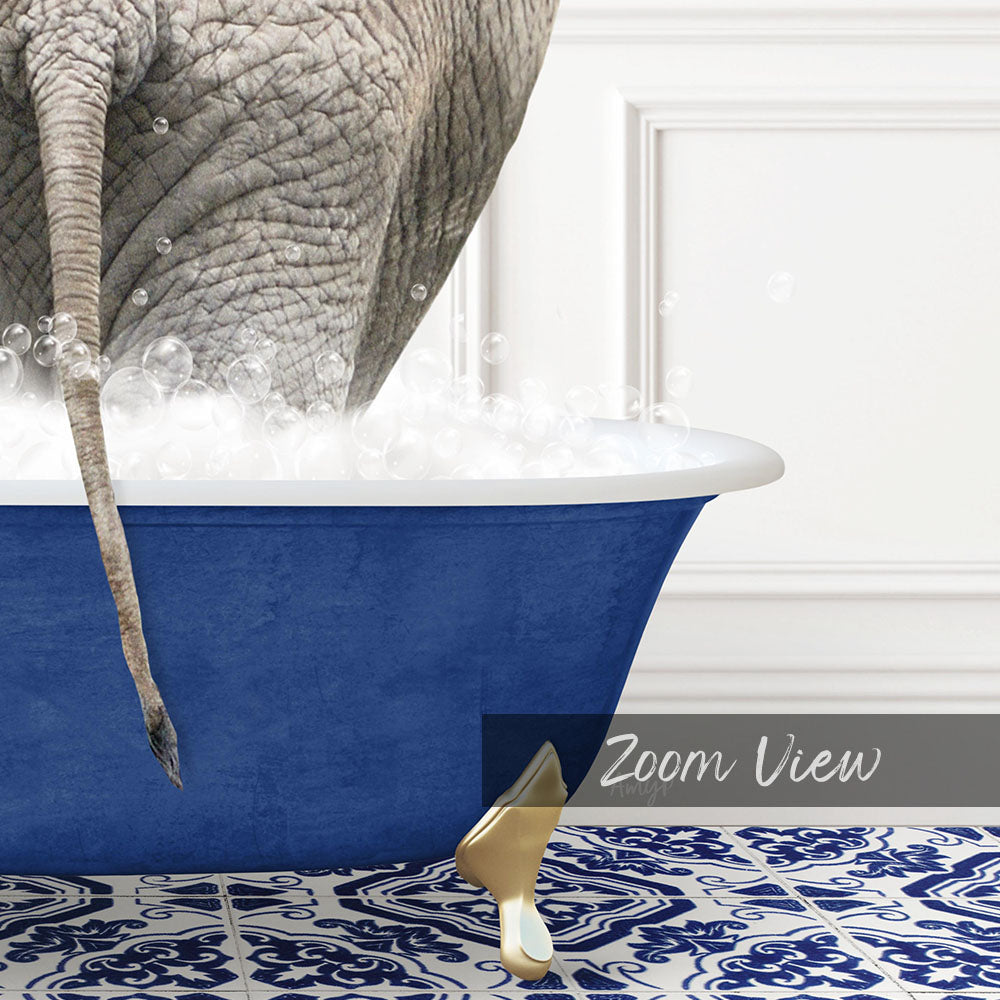 A large elephant is standing in a blue bathtub filled with bubbles, with its tail hanging over the edge.