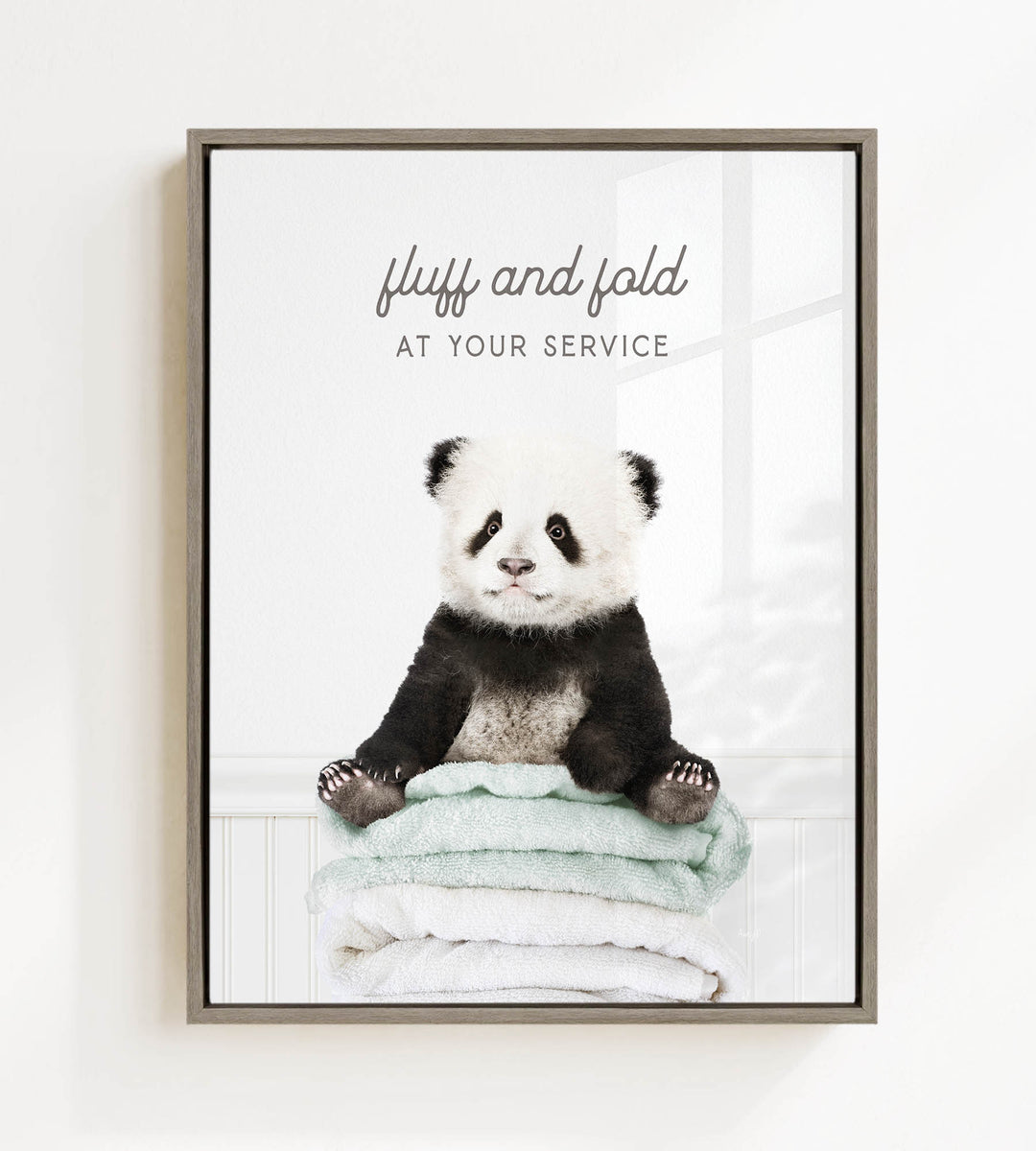 A panda bear sitting on a stack of towels, with the text "fluff and fold at your service" written above the image.