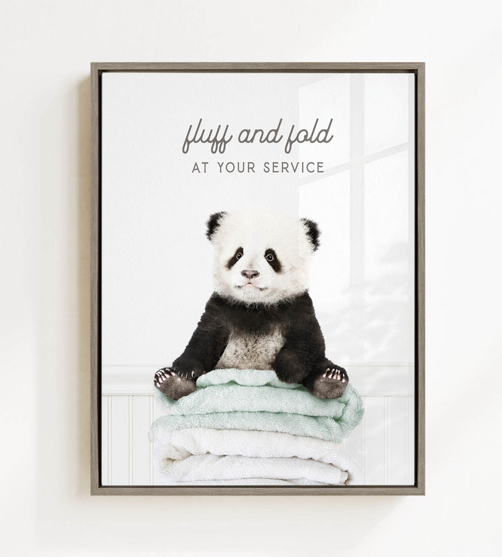 A panda bear sitting on a stack of towels, with the text "fluff and fold at your service" written above the image.