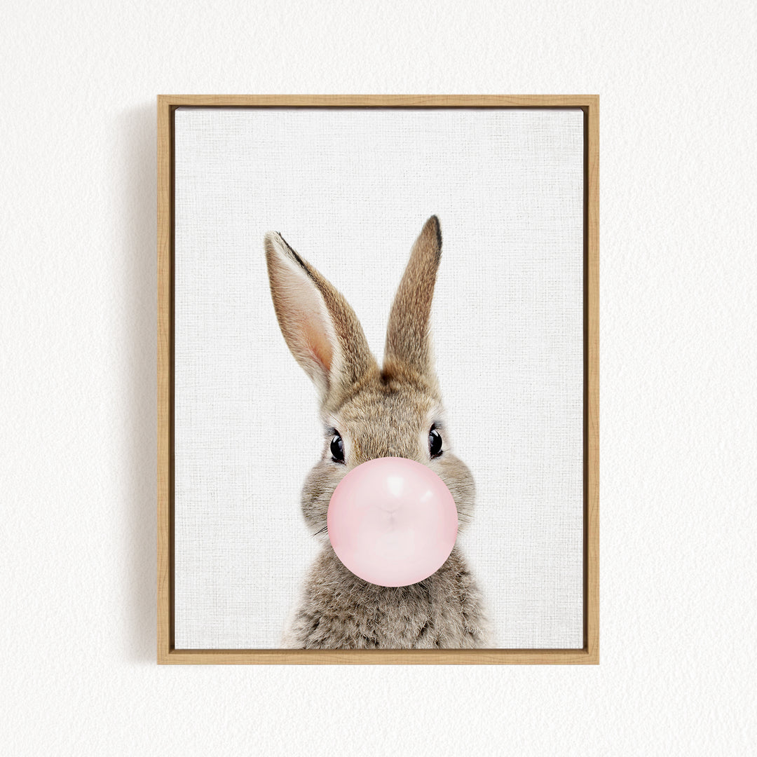 A cute rabbit is blowing a pink bubble with its nose, creating a playful and whimsical scene.