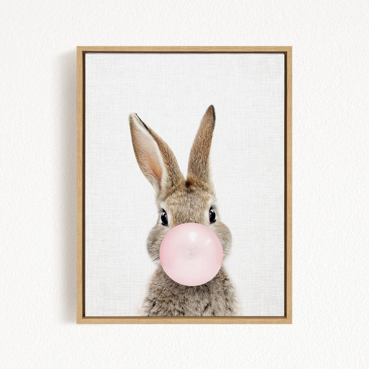 A cute rabbit is blowing a pink bubble with its nose, creating a playful and whimsical scene.