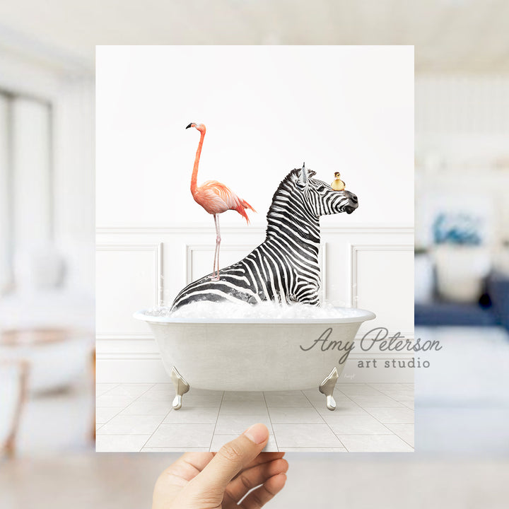 a hand holding a card with a zebra and a flamingo in a bathtub