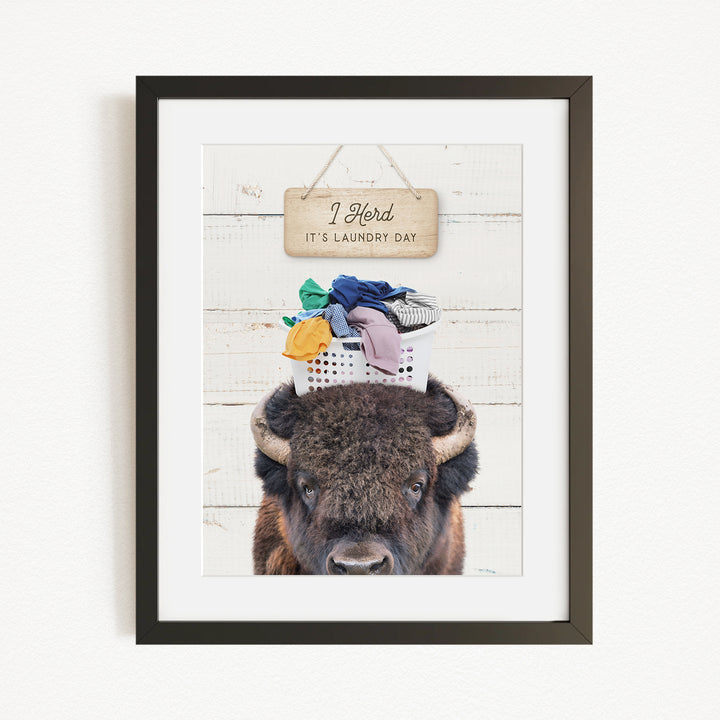 A framed image of a buffalo with a sign above it that says "I herd, it's laundry day".