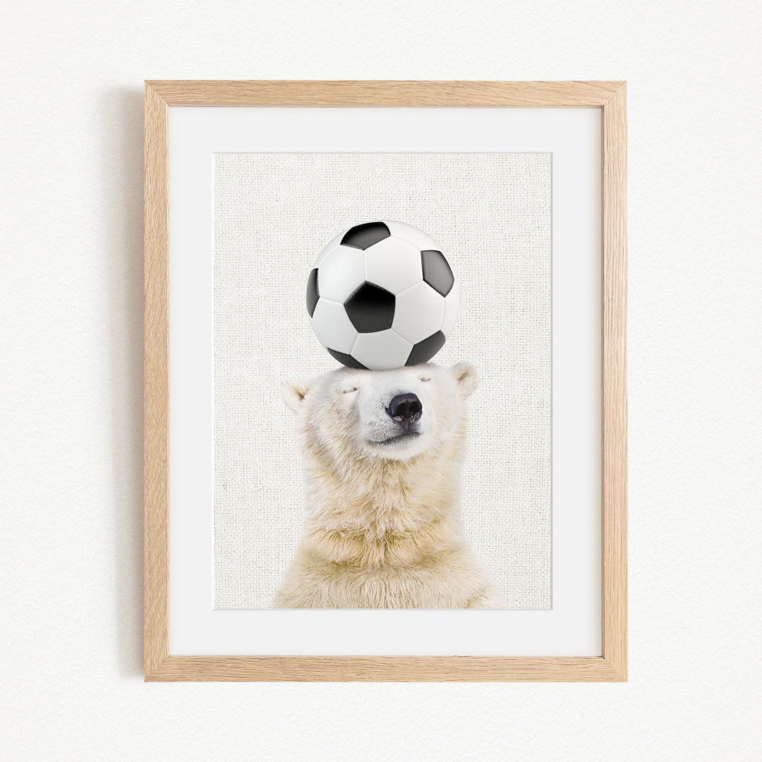 A polar bear balancing a soccer ball on its head.