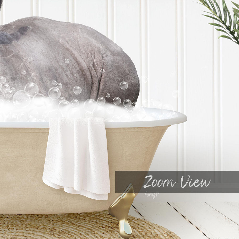 A bathtub filled with bubbles, with a towel hanging on the side and a plant in the background.