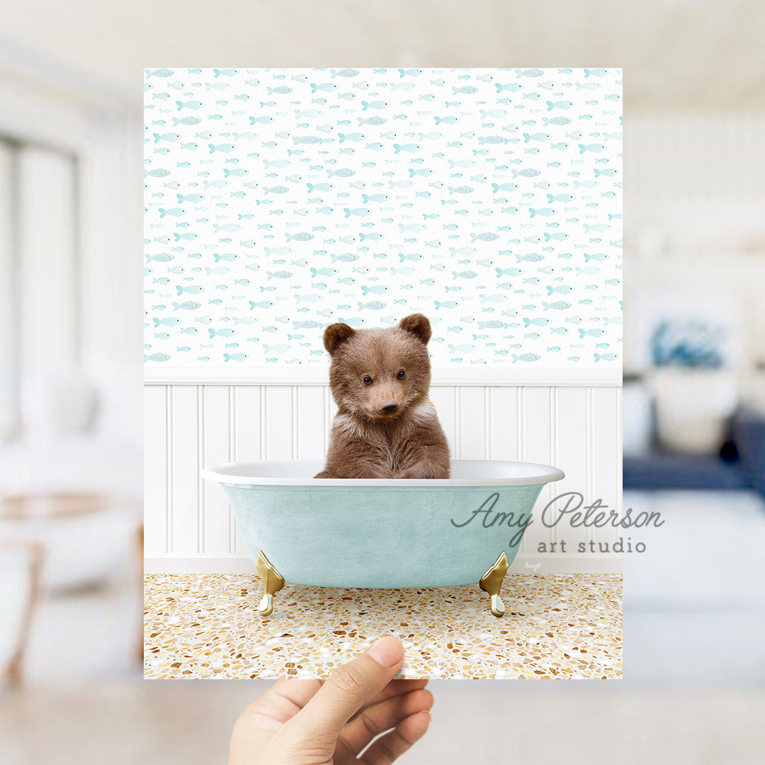 a person holding up a picture of a teddy bear in a bathtub