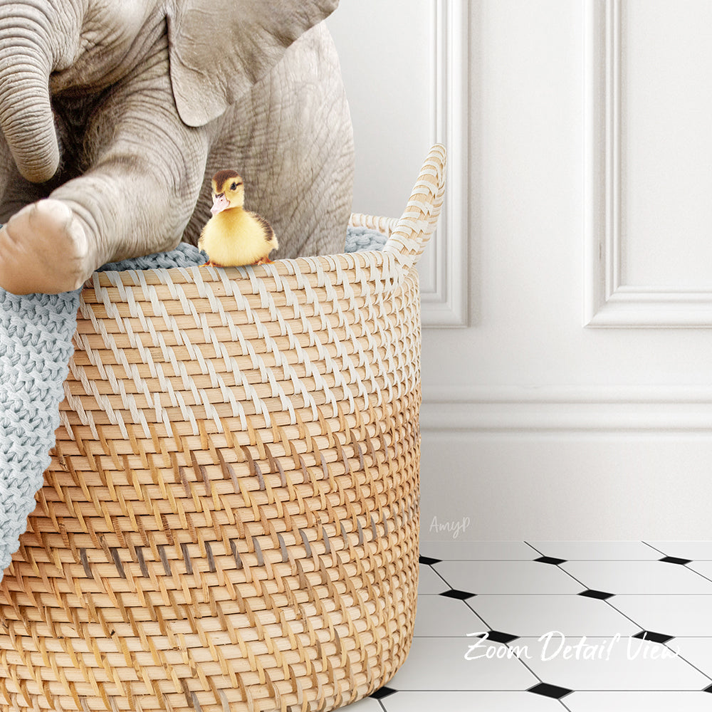 A small yellow duck sits in a woven basket, with a larger elephant trunk resting on top of the basket.