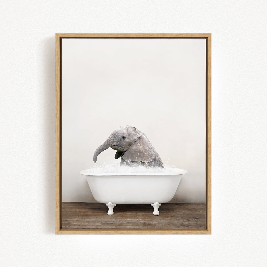 A baby elephant sitting in a white bathtub filled with water, with its trunk submerged in the water.