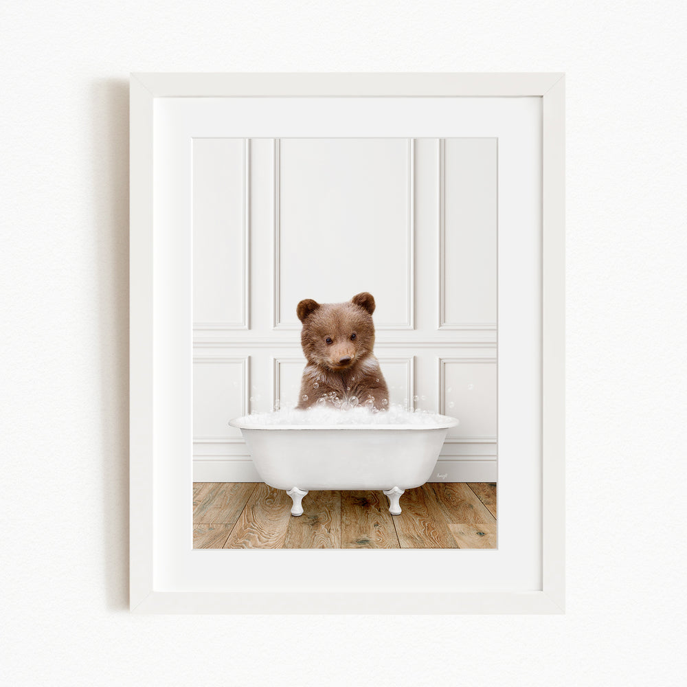 A brown bear sitting in a white bathtub filled with water, creating a playful and adorable scene.