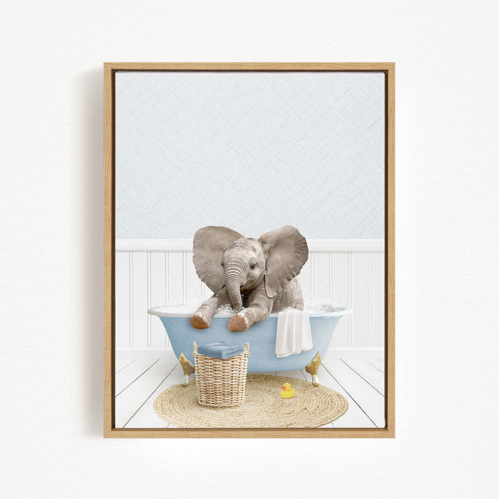 A baby elephant sitting in a blue bathtub, surrounded by a yellow rubber duck and a woven basket.