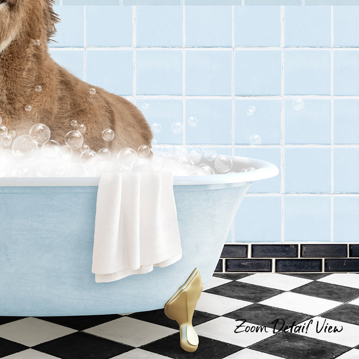 A cat sitting in a bathtub filled with bubbles, with a towel and a gold claw-like object nearby.