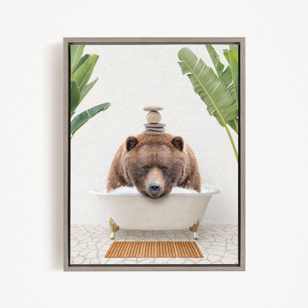 A brown bear is sitting in a white bathtub filled with water, surrounded by green plants and a wooden mat on the floor.