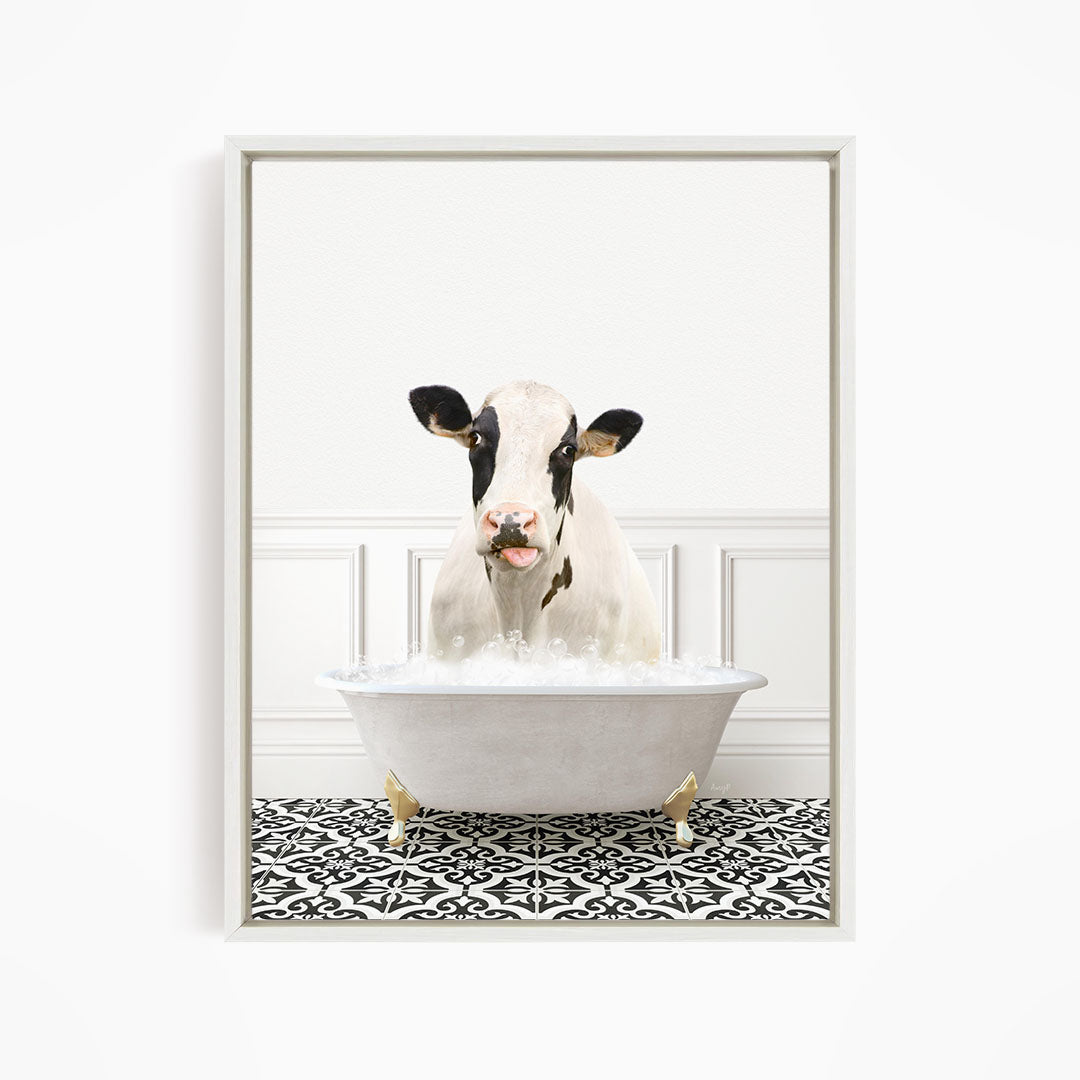A black and white cow is sitting in a white bathtub filled with water, creating a whimsical and humorous scene.
