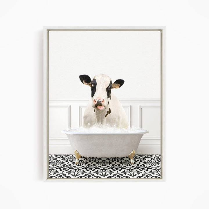 A black and white cow is sitting in a white bathtub filled with water, creating a whimsical and humorous scene.