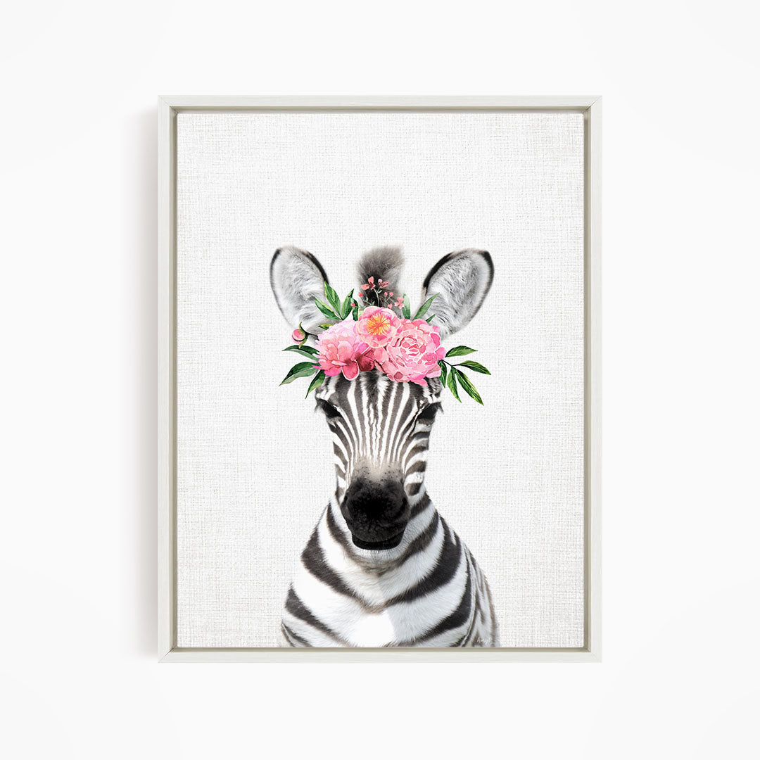 A zebra wearing a floral headpiece with pink flowers.