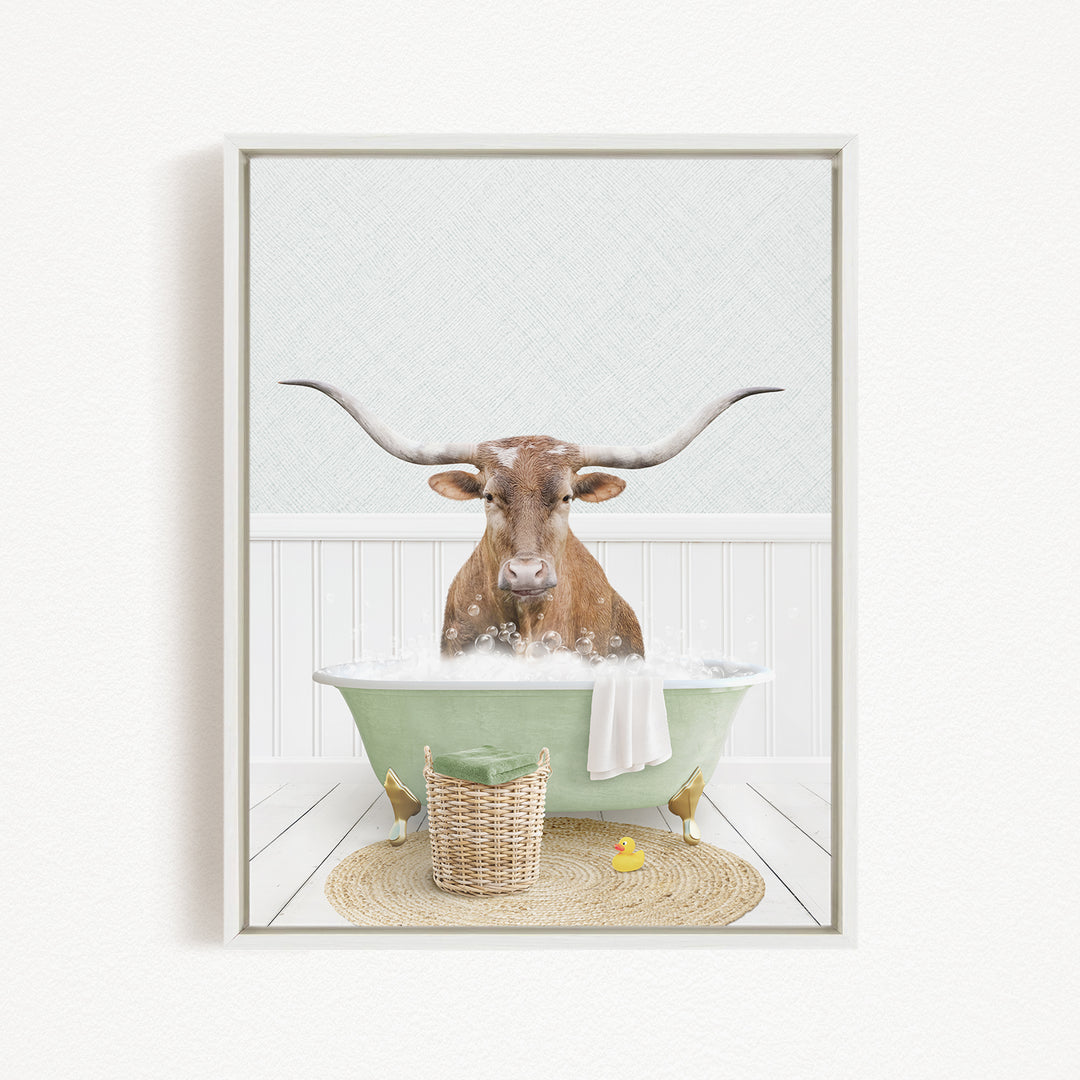 A brown cow with long horns is sitting in a green bathtub filled with bubbles, surrounded by a basket of toys and a yellow rubber duck.