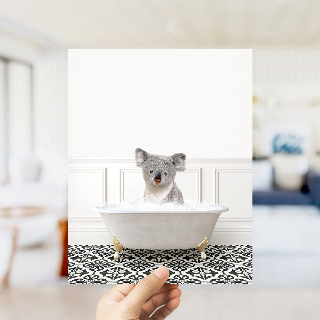 A koala sitting in a bathtub filled with bubbles, looking directly at the camera.