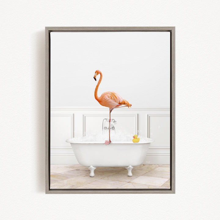 A pink flamingo stands on the edge of a white bathtub, with a yellow rubber duck floating in the water.