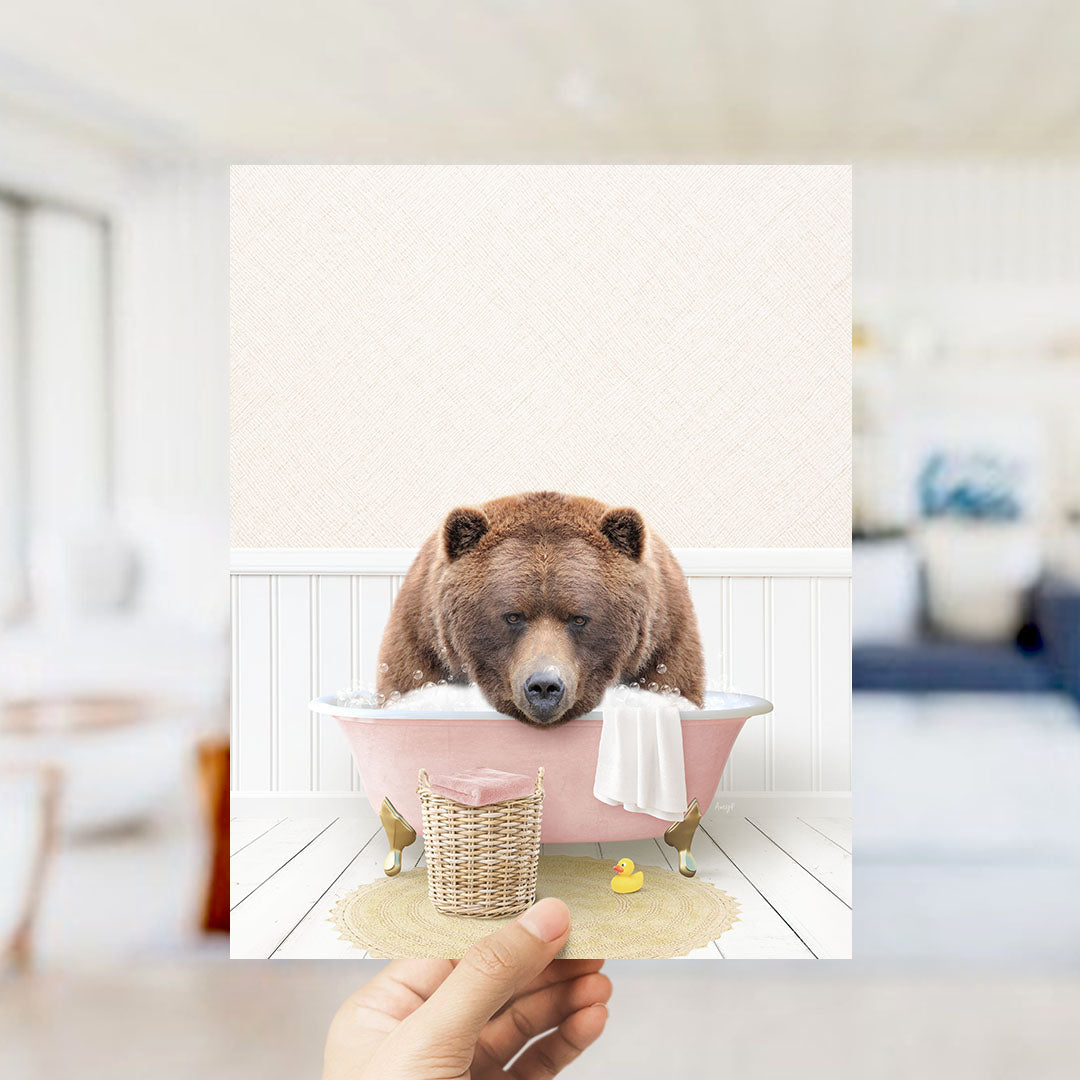 A brown bear sitting in a pink bathtub, surrounded by a yellow rubber duck and a white towel, in a cozy indoor setting.