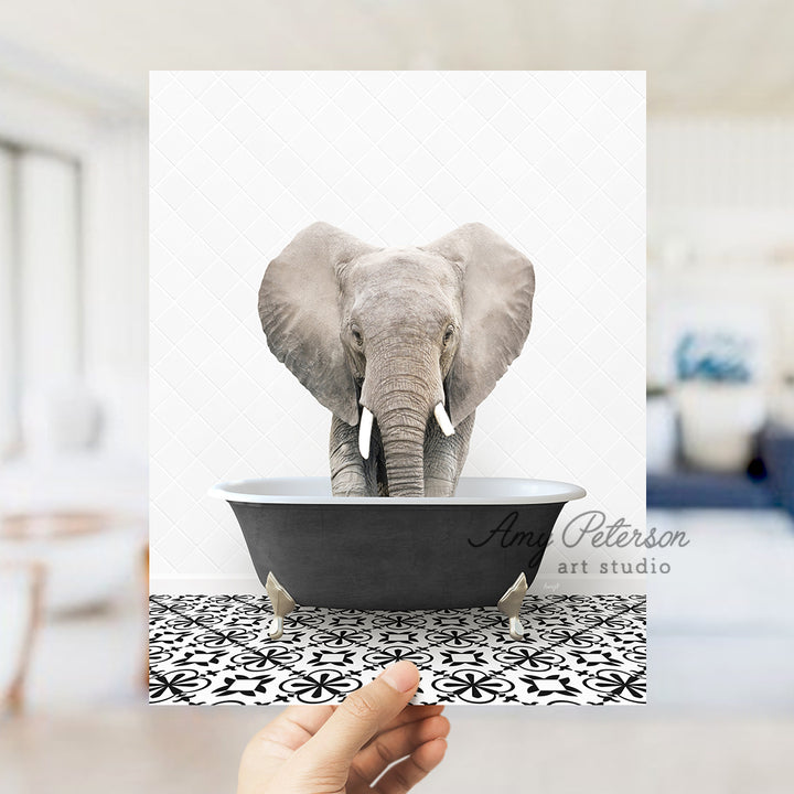 a person holding up a picture of an elephant in a bathtub