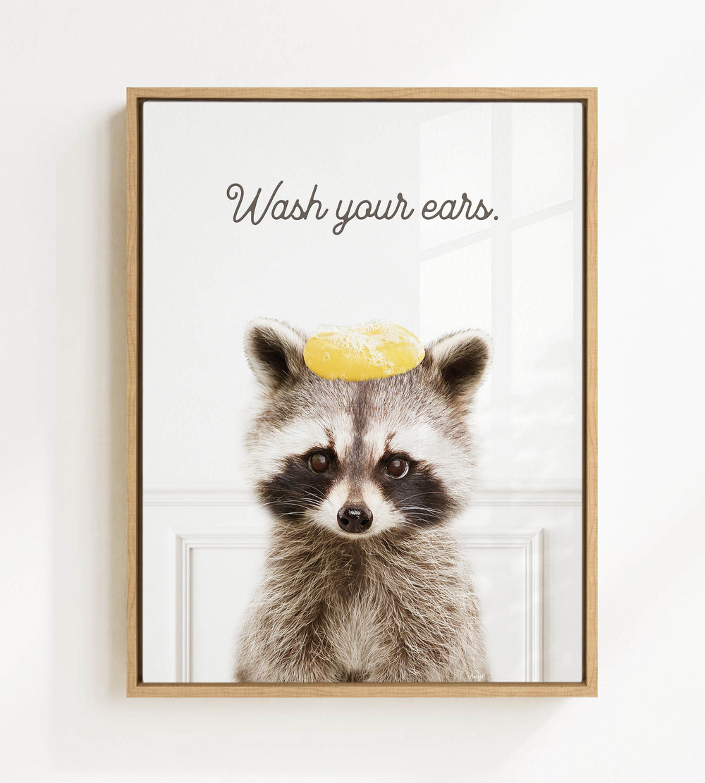 A raccoon wearing a yellow hat with the text "Wash your ears" written on it.