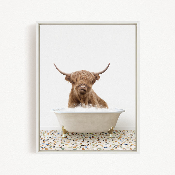 A Highland cow with long horns is sitting in a bathtub filled with water, creating a whimsical and playful scene.