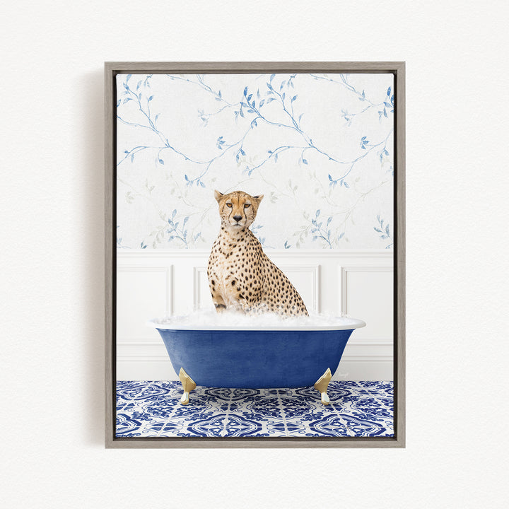 A cheetah sitting in a blue bathtub, surrounded by a patterned tile floor and a floral wallpaper background.