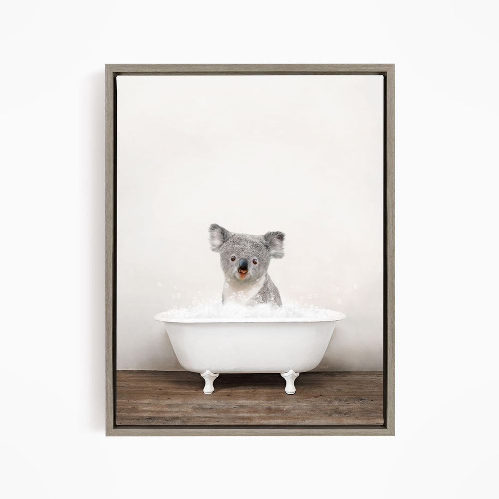 A koala bear sitting in a white bathtub filled with water, looking directly at the camera.