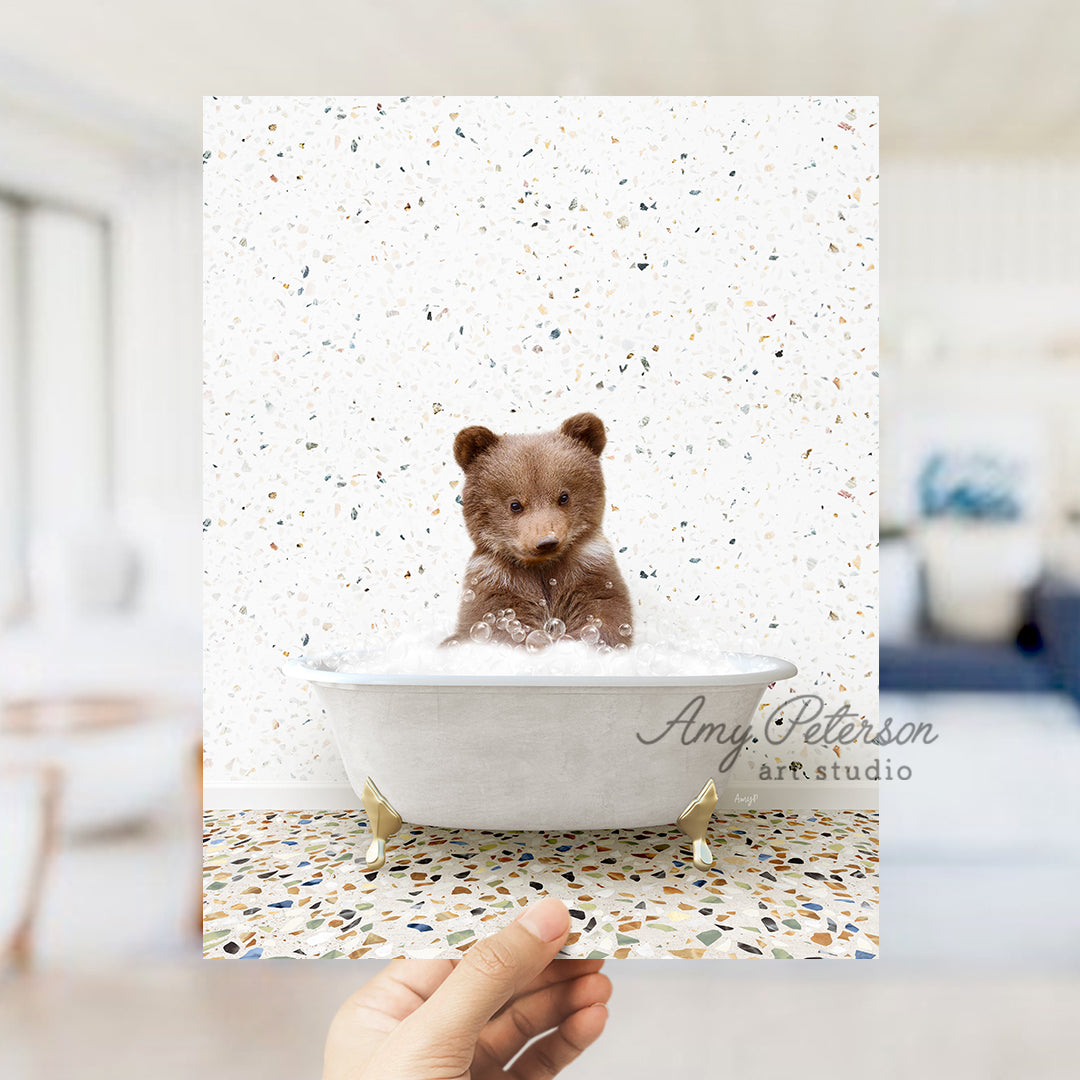 a hand holding up a polaroid picture of a teddy bear in a bathtub