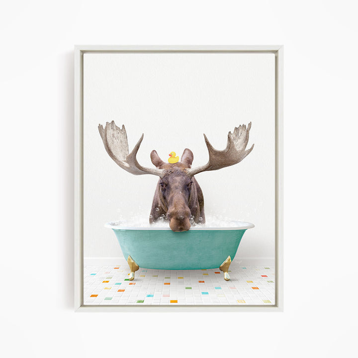 A moose with large antlers is sitting in a green bathtub, with a rubber duck floating on its head.