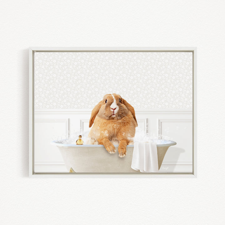 A brown rabbit sitting in a bathtub filled with water, surrounded by bubbles, with a towel and a small toy nearby.